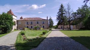 a stone driveway leading to a large house at Domaine de Monplaisir in Caylus