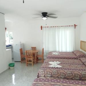 1 dormitorio con 2 camas y mesa con sillas en Hotel Quinta Paraiso, en Cocoyoc