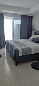 1 dormitorio con 1 cama con manta azul y gris en Apartament na plaży w La Manga, en La Manga del Mar Menor 14 fotos más