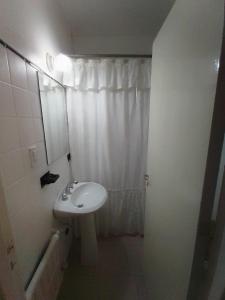 Baño blanco con lavabo y espejo en Depto. Corrientes, zona centro Mardel en Mar del Plata