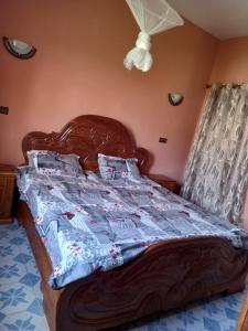 1 cama con cabecero de madera en un dormitorio en Villa meublée climatisée, en Ziguinchor