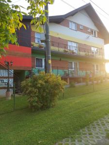 a large building with red white and blue paint on it at Apartament i pokoje u Roberta in Polańczyk