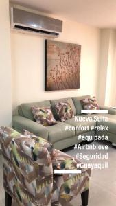 sala de estar con sofá y pintura en Garzota Suites Gardens, en Guayaquil