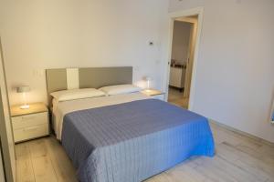 una camera con un letto e due comodini e due lampade di Novatek Apartment 202 Exclusive a Pescara