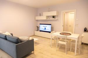 a living room with a couch and a table and a tv at Novatek Apartment 202 Exclusive in Pescara