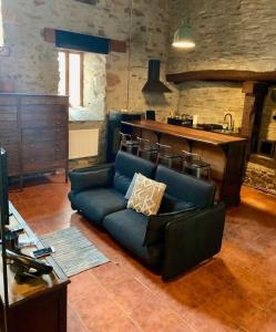 a living room with a blue couch and a bar at Mirador Yellow Door in Ponferrada