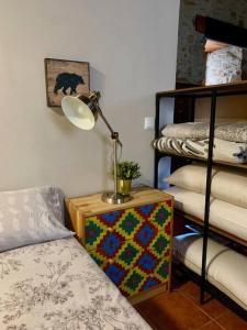 a lamp sitting on a table next to a bed at Mirador Yellow Door in Ponferrada