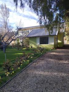une maison jaune avec allée dans une cour dans l'établissement Cabaña Liebe Inge, à San Carlos de Bariloche