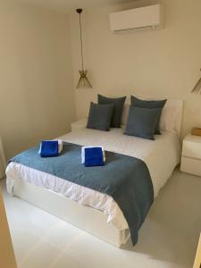 a bedroom with a large white bed with blue pillows at Cap d ail Appartement aux portes de Monaco in Saint-Antoine