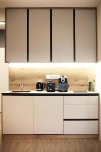 a kitchen with white cabinets and a sink at Apartmány 316 a 317 Vila Zuberec in Zuberec