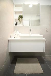 a white bathroom with a sink and a mirror at Apartmány 316 a 317 Vila Zuberec in Zuberec