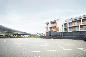an empty parking lot in front of a building at Apartmány 316 a 317 Vila Zuberec in Zuberec