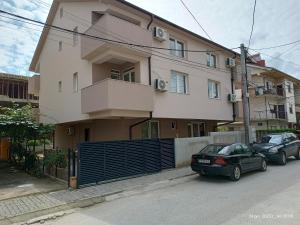 un bâtiment avec deux voitures garées devant lui dans l'établissement Grand Apartments Strumica, à Strumica