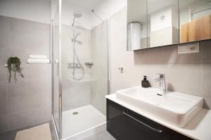 a white bathroom with a sink and a shower at Apartmány 316 a 317 Vila Zuberec in Zuberec