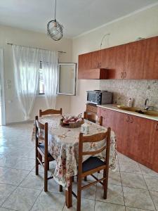 a kitchen with a table and chairs and a kitchen with a table and a table at Xristos Villa in Nea Vrasna