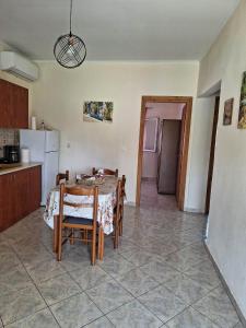 a kitchen and dining room with a table and chairs at Xristos Villa in Nea Vrasna +8 photos