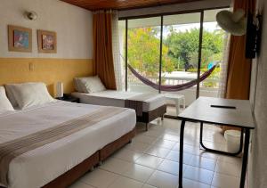 a hotel room with two beds and a window at Hotel Hacienda El Diamante in Villeta