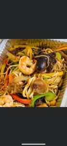 a basket filled with noodles and shrimp and vegetables at Yolyans Hotel in Goris