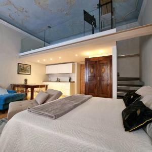a bedroom with a large white bed and a kitchen at Living The Dream in Arco