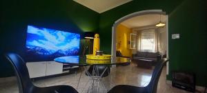 a dining room with a table and a green wall at Casa Candelina in Mendoza