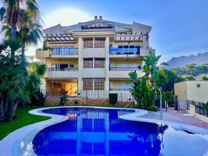 a hotel with a swimming pool in front of a building at Mar y Montana House by Gloove in Altea la Vieja