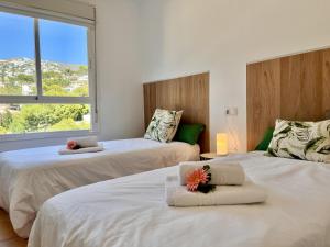 a bedroom with two beds with towels and a window at Mar y Montana House by Gloove in Altea la Vieja +24 photos