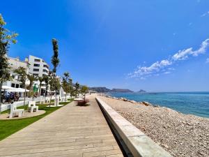 a boardwalk on a beach next to the water at Mar y Montana House by Gloove in Altea