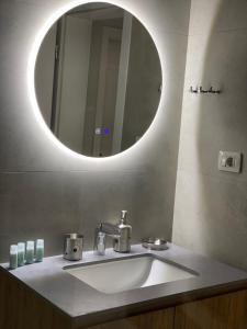 La salle de bains est pourvue d'un lavabo et d'un miroir. dans l'établissement Lucas Downtown, à Tirana