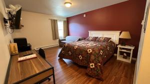 1 dormitorio con cama, mesa y sofá en Denali Rainbow Village RV Park and Motel, en McKinley Park