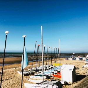 a row of boats are lined up on a beach at kerwatt in Cabourg