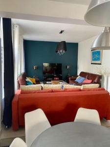 a living room with a red couch and chairs at kerwatt in Cabourg