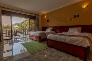 a hotel room with two beds and a balcony at Bunyonyi Overland Resort in Kabale