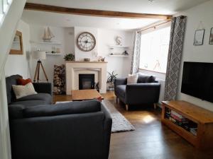 a living room with two couches and a tv at Converted Barn in Bath in Bath