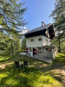 uma casa com duas cadeiras em frente em I Larici - Appartamento per sognare em Alpe Devero