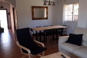 sala de estar con sofá y mesa con sillas en Villa privada en la playa 8 personas, en Marbella
