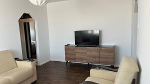 uma sala de estar com televisão numa cómoda de madeira em Central Apartment em Mangalia