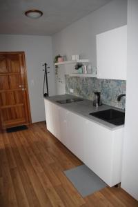 uma cozinha com balcões brancos e piso em madeira em Apartamenty AGAT em Pieszyce