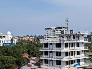 a white building with a balcony on top of it at Success Apartments - Silver in Mwanza