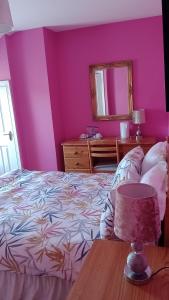 una camera da letto con pareti rosa e un letto con tavolo di Bundoran Guesthouse a Bundoran
