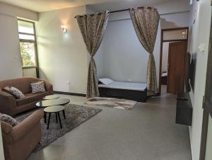 a living room with a couch and a table at Success Apartments - Silver in Mwanza