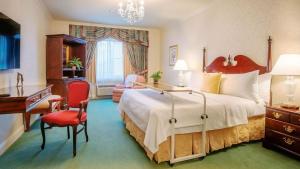 um quarto de hotel com uma cama grande e uma secretária em The Bristol Hotel Campbell San Jose em Campbell