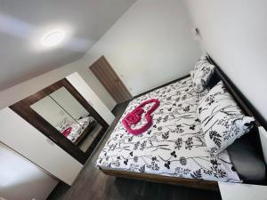 a bedroom with a bed with a black and white comforter at Apartmani LU&LO in Delnice