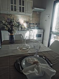 un tavolo con un piatto e un vaso di fiori di Complejo Nogales a Tunuyán
