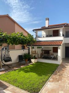 a backyard of a house with a grass yard at Family Beach Apartments in Peroj