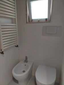 a white bathroom with a toilet and a sink at VincesilHouse in Mola di Bari +20 photos
