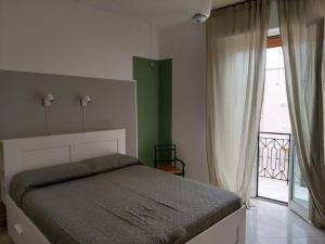 a bedroom with a bed and a large window at VincesilHouse in Mola di Bari