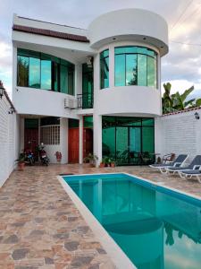 a house with a swimming pool in front of it at Alojamiento Familiar Villa Palmeras in Tarapoto