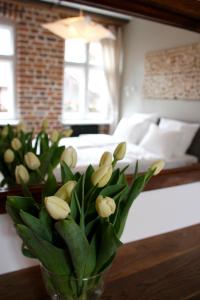 eine Vase mit Blumen auf einem Tisch in einem Schlafzimmer in der Unterkunft Apartamenty Luizjana in Toruń