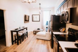 a kitchen and living room with a table and a refrigerator at Inn On Central in Le Mars