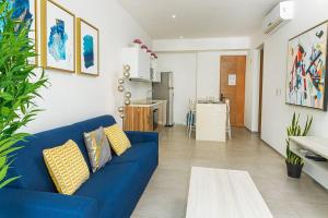 sala de estar con sofá azul y cocina en Lovely Space 4 Blocks From The Beach en Playa del Carmen